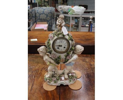 Continental German ceramic mantle clock depicting cherubs holding a rose vine clock face with enamelled face Roman and Arabic