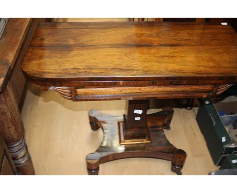 A William IV rosewood folding card table, circa 1830, D shaped top enclosing maroon inlay surface, on a square column above a