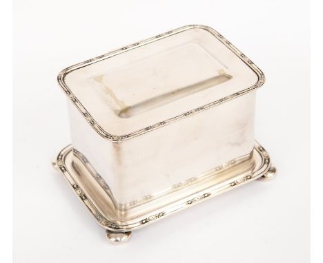 A 1920's silver plated tea caddy with affixed stand raised on button feet