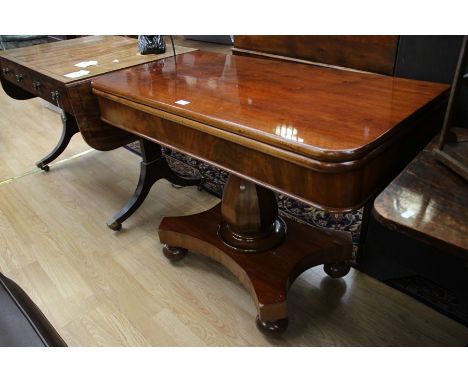 A mid Victorian mahogany fold over card table, the upper section raised on an octagonal baluster shaped column and standing o