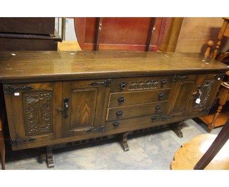 &nbsp;A 20th Century oak sideboard, rectangular top above four tier drawers with two panel enclosing cupboards each side, on 