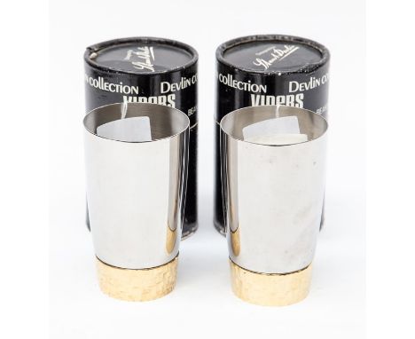 Stuart Devlin for Viners, a pair of stainless steel beakers, with gold plated rusticated bases, complete with boxes (2)