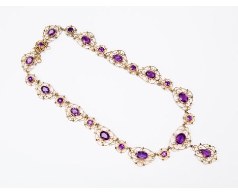 An Edwardian amethyst and rose gold necklace, comprising oval and round cut faceted amethysts with open scroll and bead surro