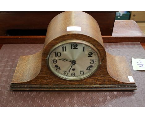 An early 20th Century oak eight day mantle clock, circa 1930, the case of Napoleon shape, the dial with Arabic numerals, the 