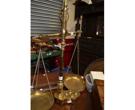 A set of brass scales complete with full set of weights, but missing a chain to one pan, along with two reproduction swords