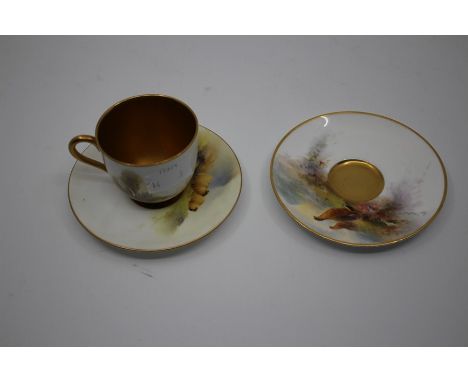 A Royal Worcester coffee cup and saucer, painted with pheasants in landscape signed by James Stinton, gilt interior, puce mar