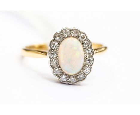 An opal and diamond set 18ct gold cluster ring, the oval opal approx. 8mm x 5mm,&nbsp; with a border of brilliant cut diamond