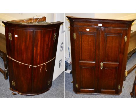 A George III panelled oak hanging corner cupboard and a bow fronted example of similar date