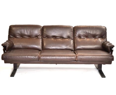 A 1970s Danish Brown Leather Three Seater Sofa, with buttoned back supports and arms, with three squab cushions, raised on sq