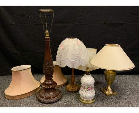 An early 20th century carved mahogany table lamp, 77cm tall;  a brass urnular table lamp;  others, (5). 