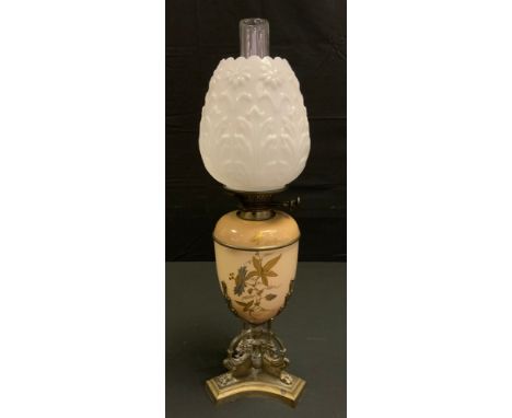 A Doulton style oil lamp, decorated with stylised foliage, milk glass shade, the cast triform base with Griffin scrolls and p