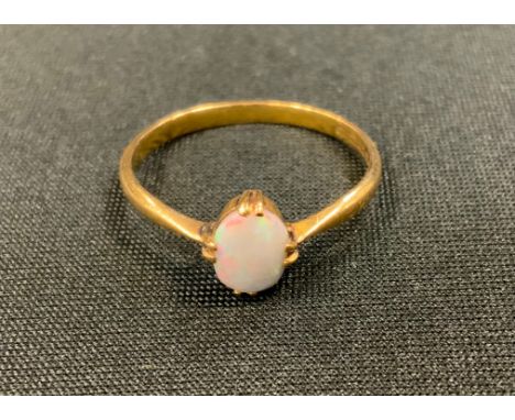 An opal solitaire ring, oval opal flashing red, violet, Green colour play, 22ct gold shank, size W, 3.1g gross 