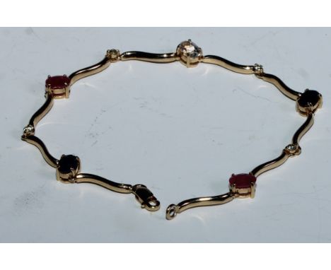 A fancy link ruby, sapphire, diamond and white stone bracelet, shaped wave bar links divided by alternating coloured and clea