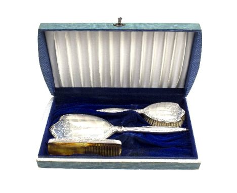 A silver dressing set, comprising hand mirror, hairbrush and comb, marked 'International Sterling', monogrammed LM within fit