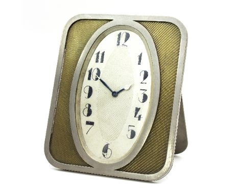 An Art Deco clock by Tiffany & Co., the oval face marked for London, made in France, within a gilt engine turned rectangular 