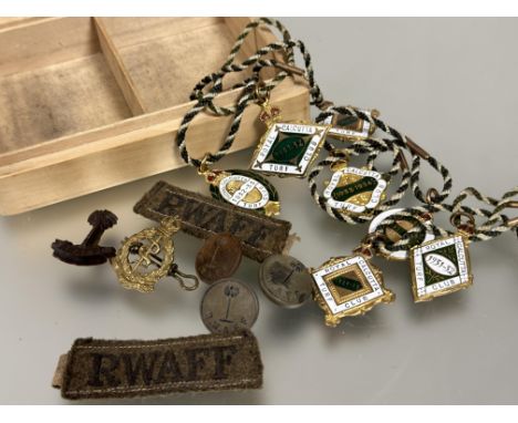 A treen box containing two WWII RWAFF tunic badges, three brass buttons and cap badge, a royal a Royal Army Medical Corps cap