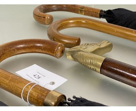 A group of three yellow metal mounted umbrellas, early to mid 20th century, together with another umbrella and a brass handle