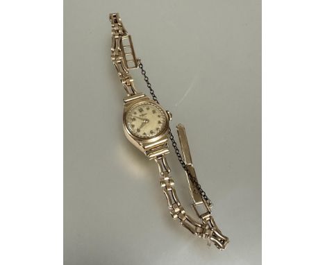 A 9ct Rotary ladys wristwatch with silvered dial and arabic numerals on 9ct gold gate link bracelet and metal safety chain D 