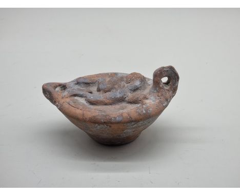 Antiquities: a large Roman terracotta oil lamp, relief decorated with an erotic scene, 16cm wide.&nbsp; 