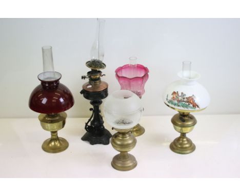 Five late 19th / early 20th century oil lamps to include a brass example with etched cranberry glass shade (approx 48cm tall)