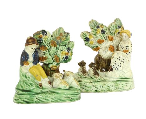 A Pair of Prattware Bocage Groups, attributed to Tittensor, circa 1820, as a shepherd and shepherdess each sitting before a t