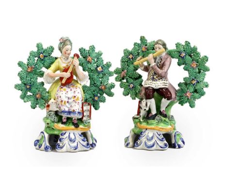 A Pair of Walton-Type Pearlware Figures of Musicians, circa 1800, seated before bocage, she with a lute, he with a flute, bot