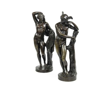 After the Antique: A Pair of Bronze Figures of Apollo and Mercury, both leaning against a tree trunk, Apollo holding a lyre, 