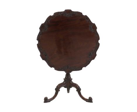 A George III Carved Mahogany Tripod Table, 3rd quarter 18th century, the moulded pie-crust tilt-top with a C-scroll and flowe