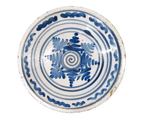 An English Delft Charger, possibly Vauxhall, late 17th century, painted in blue with a central spiral within radiating dashes