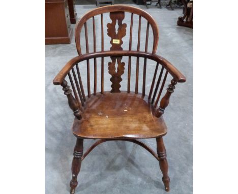 An early 19th century ash Windsor chair with yew wood arms, fretted splat and top rail, raised on ring turned splayed legs un