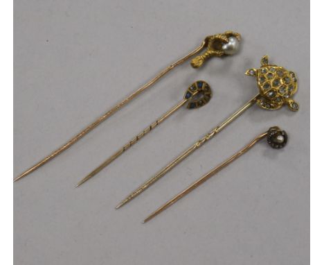 An early 20th century yellow metal and diamond set turtle stick pin and three other stick pins.