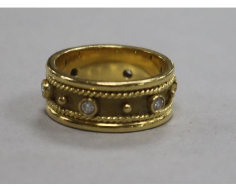 A modern 18ct gold and diamond fancy band, set with six round cut stones, size M.