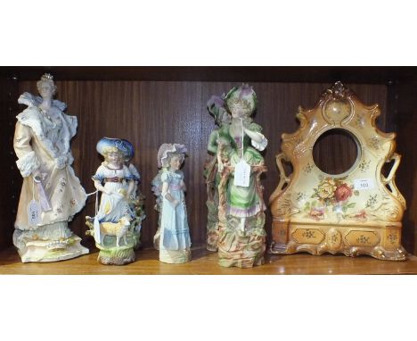A ceramic clock case decorated with flowers, 34cm high, 28cm wide, (no clock), three pairs of figure ornaments and one other.