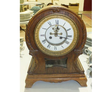 An oak-cased arched-top striking mantel clock with visible escapement, 38cm high and a stained wood striking mantel clock wit