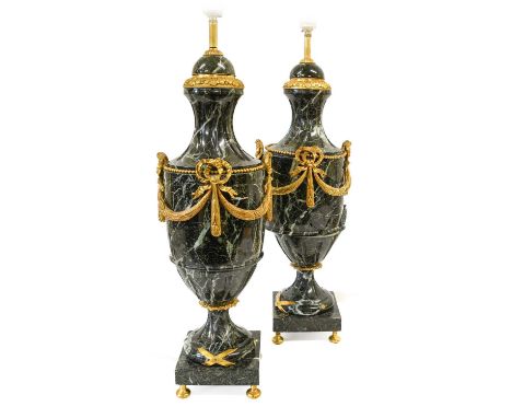 A Pair of Louis XVI Style Gilt Metal Mounted Veined Marble Lamp Bases, of urn form applied with ribbon-tied swags, on circula