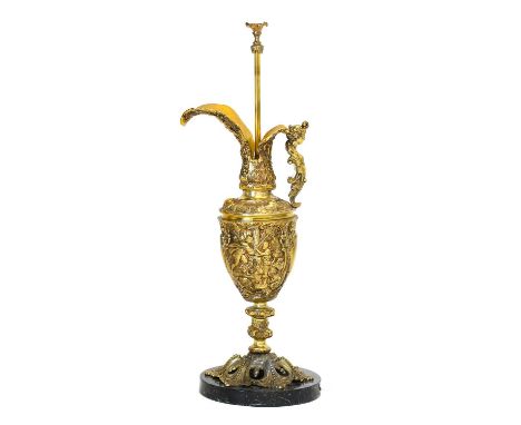 A Gilt Metal Ewer, in Renaissance style, with mermaid handle, cast with mythical figures, on a grey marble base, converted to