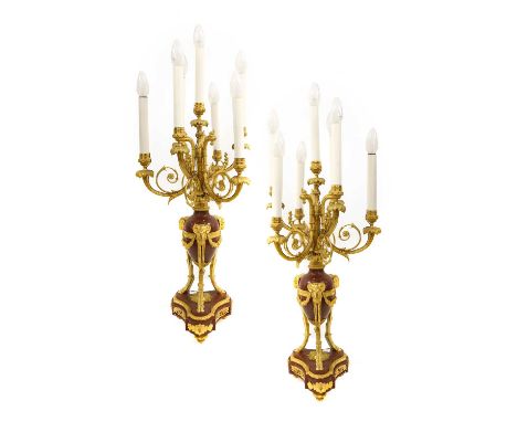 A Pair of Gilt Metal Mounted Rouge Marble Six-Light Candelabra, in Louis XVI style, with urn sconces and classical scroll bra