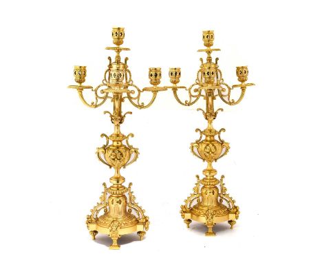 A Pair of Gilt Metal Five-Light Candelabra, in Louis XIV style, with pierced drum sconces, circular drip pans and reeded and 