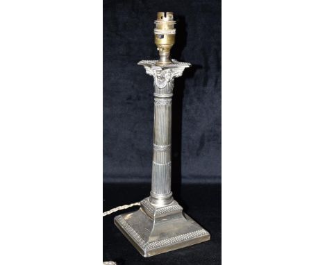 A WEIGHTED SILVER CANDLESTICK CONVERTED FOR LAMP USE The candlestick of Corinthian design with faded London hallmark, height 