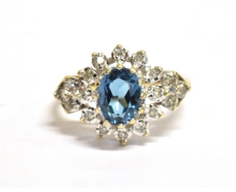 A 9CT GOLD DIAMOND GEM SET CLUSTER RING  the oval facetted turquoise coloured gem set in a cluster of twelve small diamonds t