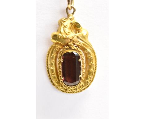 A GARNET SET PENDANT PIECE  the facetted rectangular cut garnet raised and set in an ornate yellow metal setting with rope tw