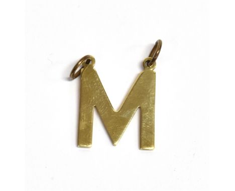 A 9CT GOLD LETTER M PENDANT PIECE The pendant fitted with two jump rings and hallmarked for London 1975, measurement 2.2 x 1.