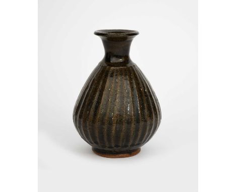 ‡ Bernard Leach CBE (1887-1979)a stoneware bottle, 1958, the fluted tapering body with flaring cylindrical neck, covered to t