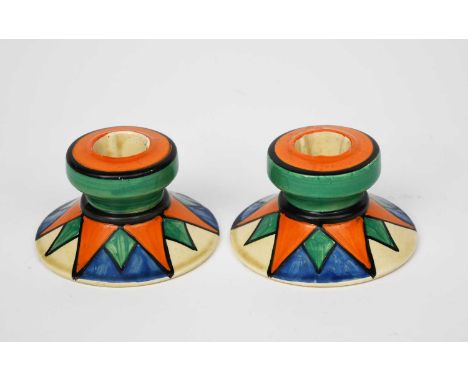 'Original Bizarre' a pair of Clarice Cliff Bizarre candlesticks, shape no.331, painted with radiating star design in orange, 