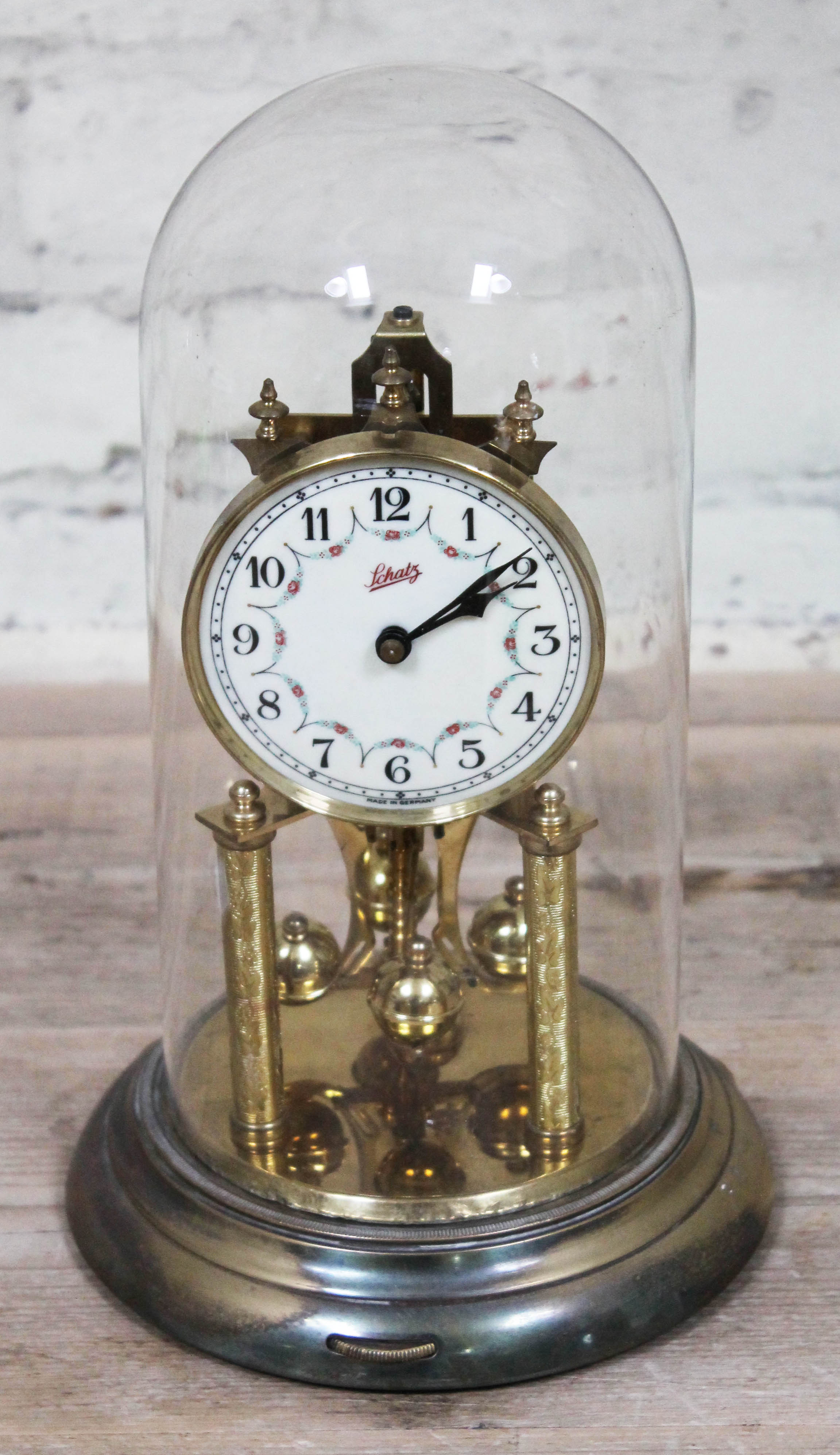 A Schatz torsion clock under glass dome, height 32cm.