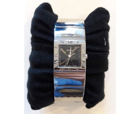 A ladies Guess stainless steel bangle wristwatch.  