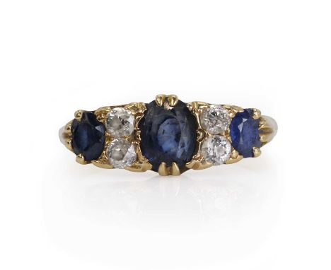 An 18ct gold sapphire and diamond ring  with three mixed cut blue sapphires and four old mine cut diamonds, in a claw setting