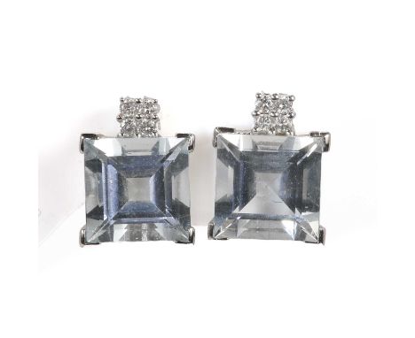 A pair of aquamarine and diamond stud earrings, with a square step cut aquamarine, claw set at the corners with chevron claws