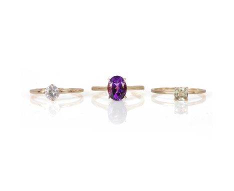 Three 9ct gold gem set rings, comprising an amethyst and diamond ring, with an oval faceted amethyst and two hidden round bri
