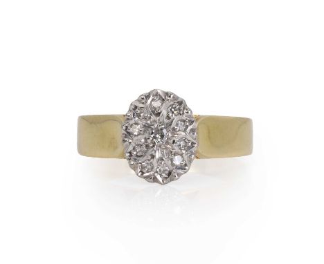 A gold diamond cluster ring,  with a cluster of eight cut diamonds, all grain set and the oval head faced in white, to a wire